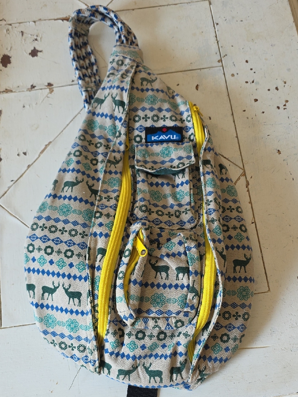 Kavu Beige Patterned Sling Bag with Blue & Green Accents and Yellow Zippers